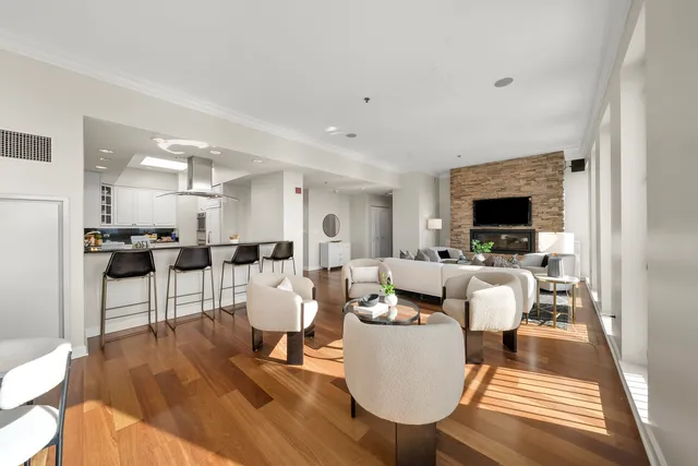 a living room with furniture a flat screen tv and kitchen view