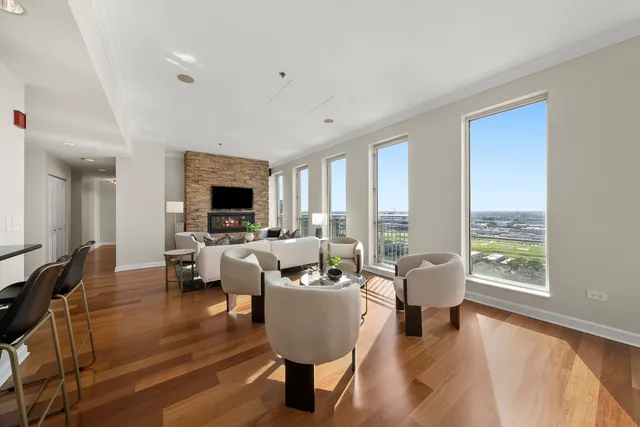 a living room with fireplace furniture and a large window