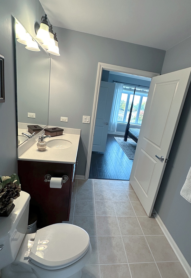 1199 East Port Clinton Road, Unit 304 Vernon Hills, IL 60061 - Photo 23 of 29 a bathroom with a toilet a sink and mirror