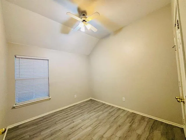 an empty room with a window and a fan