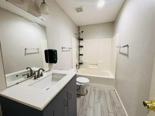 a bathroom with a sink a toilet a shower and a mirror