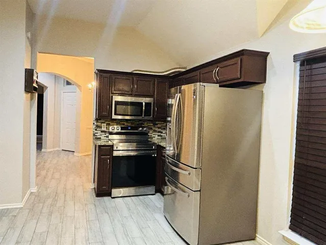 a kitchen with stainless steel appliances a refrigerator stove and microwave