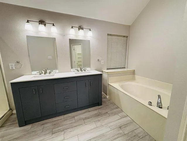 a spacious bathroom with a double vanity sink tub double and mirror