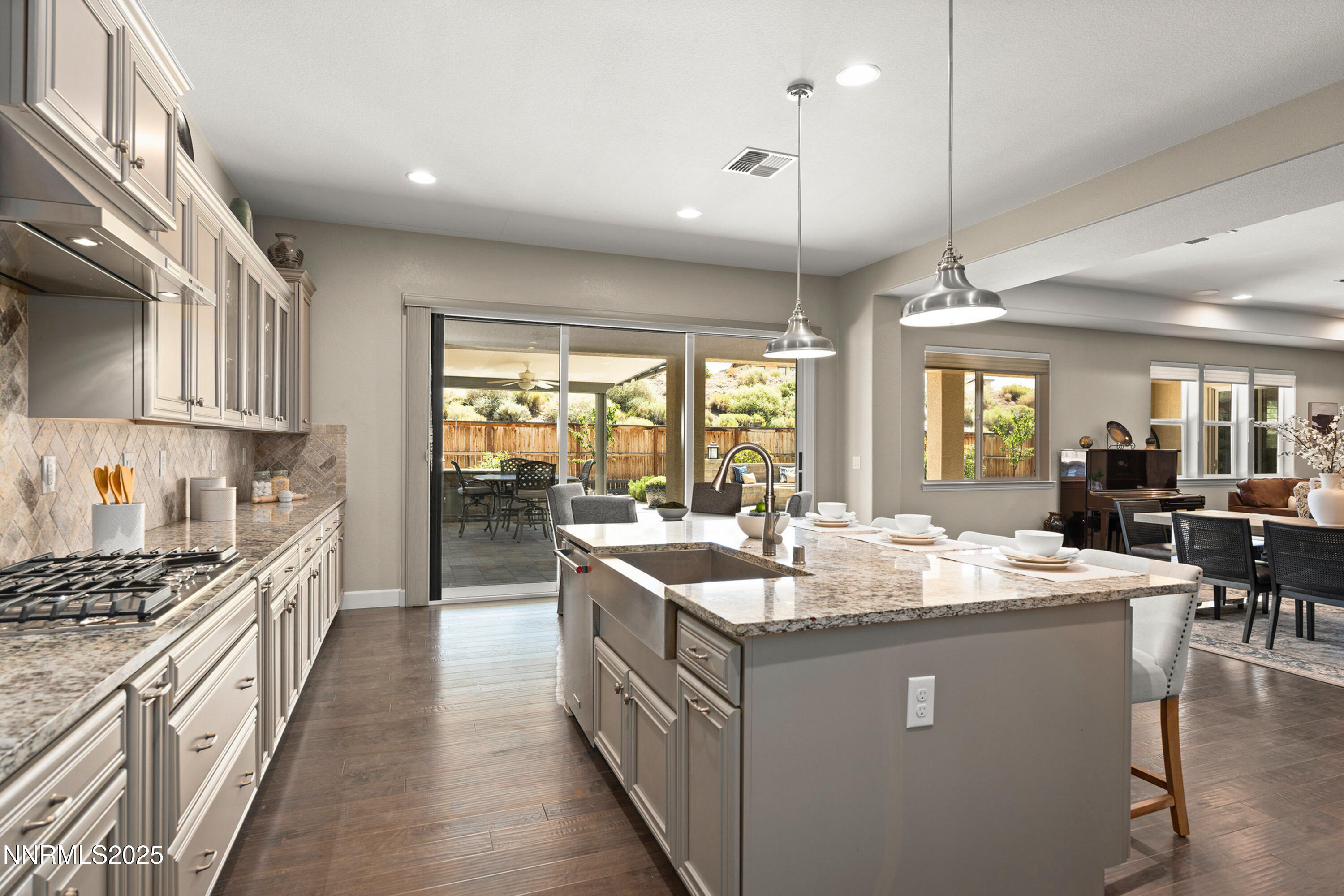 2910 Hasufel Way Reno, NV 89521 - Photo 15 of 46 a large kitchen with kitchen island a stove a sink a dining table and chairs with wooden floor