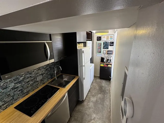 a kitchen with stainless steel appliances granite countertop a refrigerator and a sink