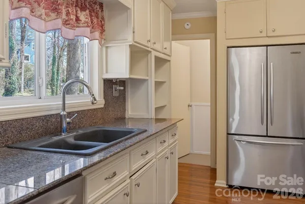 a kitchen with stainless steel appliances granite countertop a refrigerator and a sink
