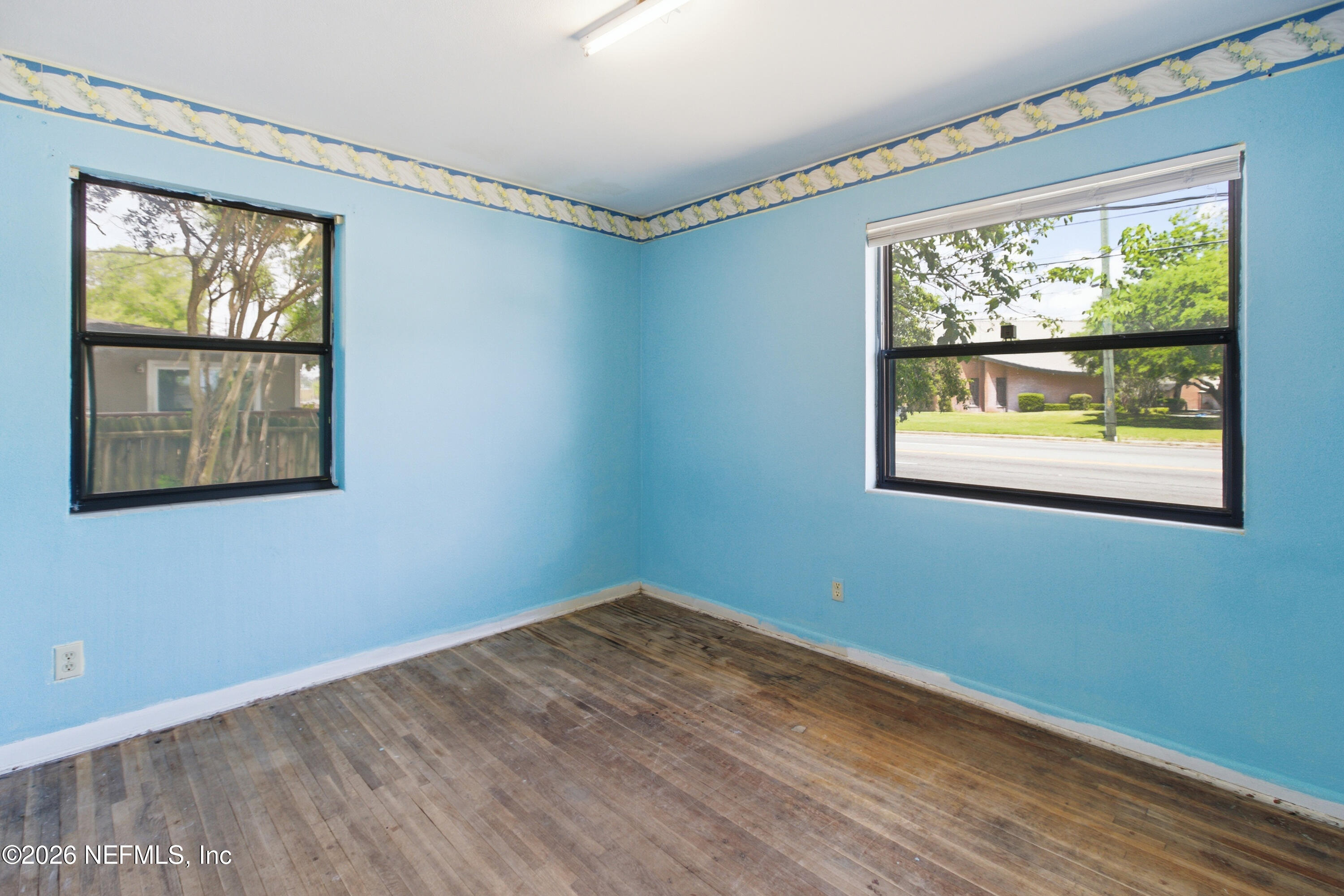 6818 Merrill Road Jacksonville, FL 32211 - Photo 12 of 21 a view of an empty room with wooden floor and a window