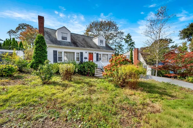 a front view of a house with a yard and potted plants