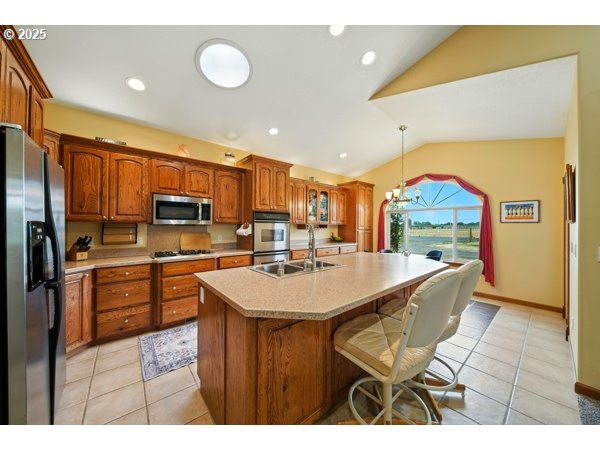 84634 Winesap Road Milton Freewater, OR 97862 - Photo 8 of 46 a kitchen with stainless steel appliances kitchen island granite countertop a refrigerator a stove top oven a sink with island and chairs