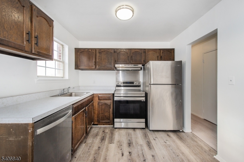 322 Richard Mine Road, Unit F5 Wharton, NJ 07885 - Photo 4 of 22 a kitchen with a sink a refrigerator and a stove top oven
