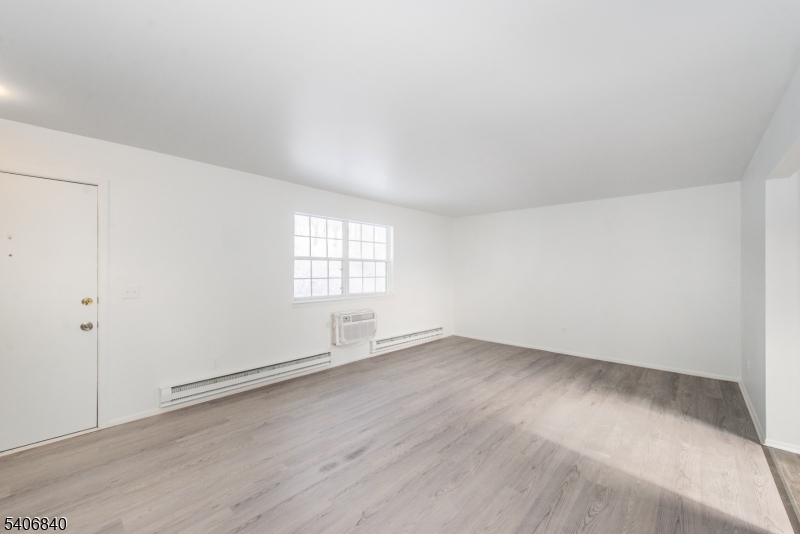 322 Richard Mine Road, Unit F5 Wharton, NJ 07885 - Photo 10 of 22 an empty room with wooden floor and windows