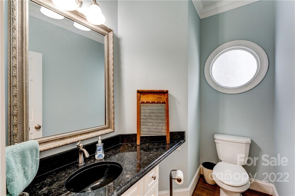 4027 Windward Drive Tega Cay, SC 29708 - Photo 19 of 44 a bathroom with a granite countertop toilet a sink and a mirror