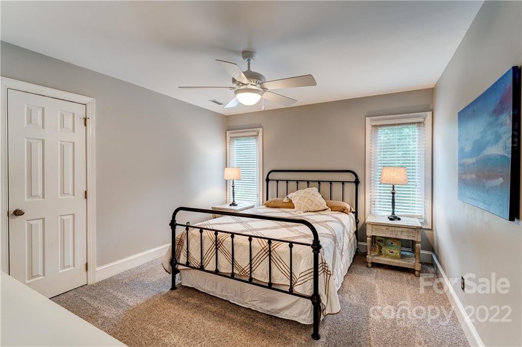 4027 Windward Drive Tega Cay, SC 29708 - Photo 30 of 44 a bedroom with a bed and a chandelier