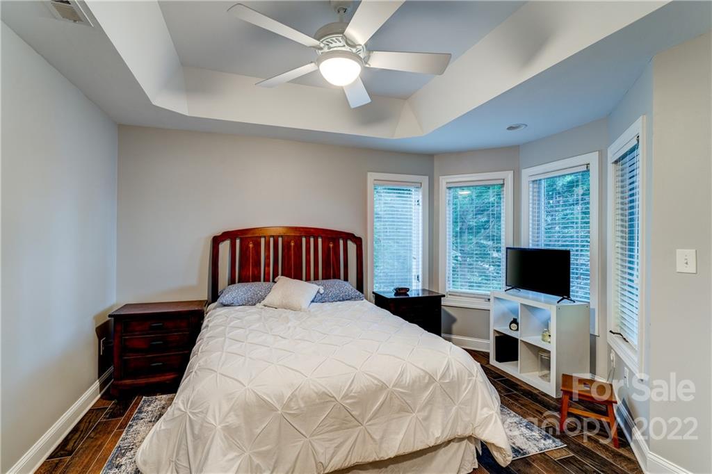 4027 Windward Drive Tega Cay, SC 29708 - Photo 37 of 44 a bedroom with a large bed and a flat tv screen on dresser