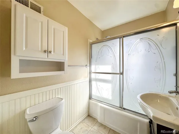 a bathroom with a sink a mirror a toilet and a window