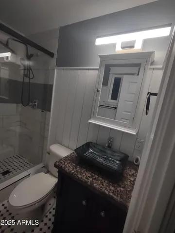 a bathroom with a granite countertop sink toilet and shower