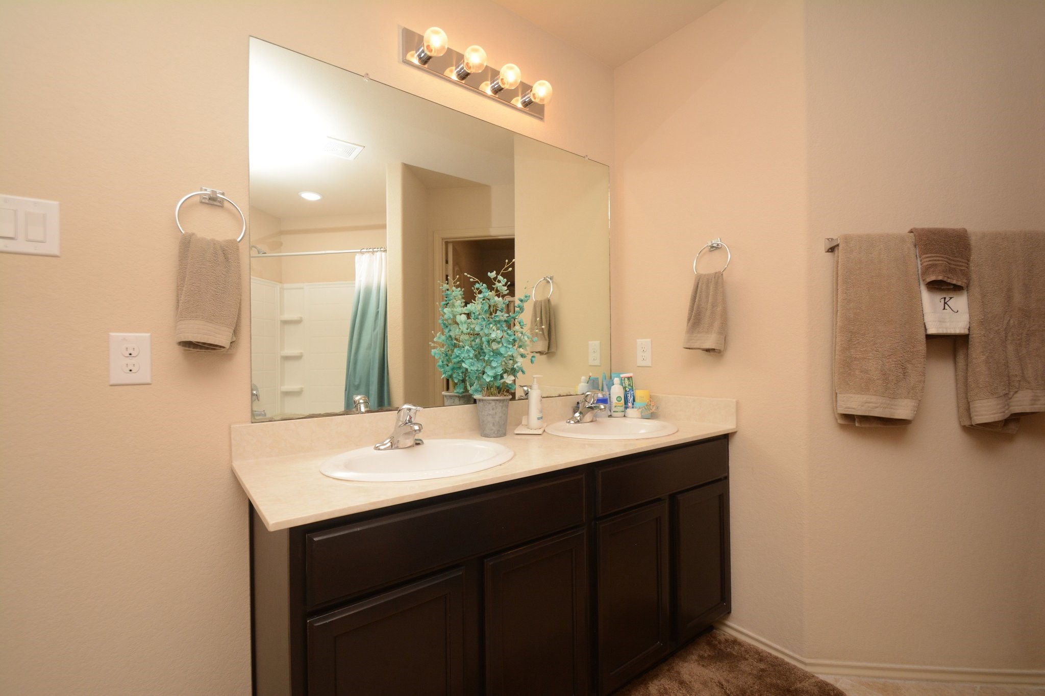 23318 Dukes Run Drive Spring, TX 77373 - Photo 29 of 41 This bathroom features a dual-sink vanity with dark cabinets, a large mirror, and ample lighting. Neutral tones create a warm, inviting atmosphere, and there's a shower and soaking tub.