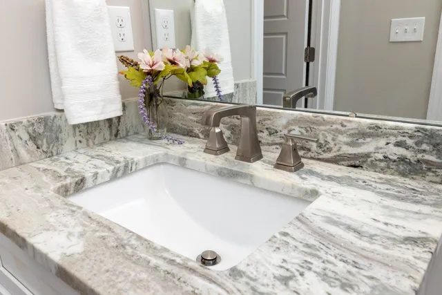 a bathroom with a granite countertop sink and a mirror