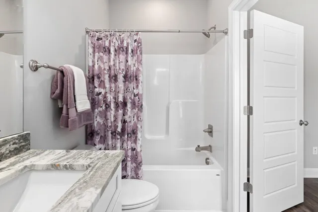 a bathroom with a granite countertop sink toilet and shower