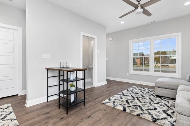 a living room with a couch and a window with wooden floor