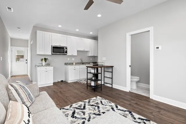 a living room with stainless steel appliances furniture or couch and a kitchen view