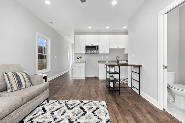 a living room with stainless steel appliances furniture and a rug