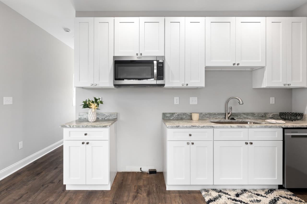 1013 B Street Waynesboro, VA 22980 - Photo 7 of 27 a kitchen with stainless steel appliances granite countertop a sink a stove and a microwave with wooden floor