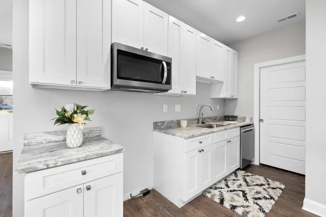 a kitchen with stainless steel appliances granite countertop a sink and a stove