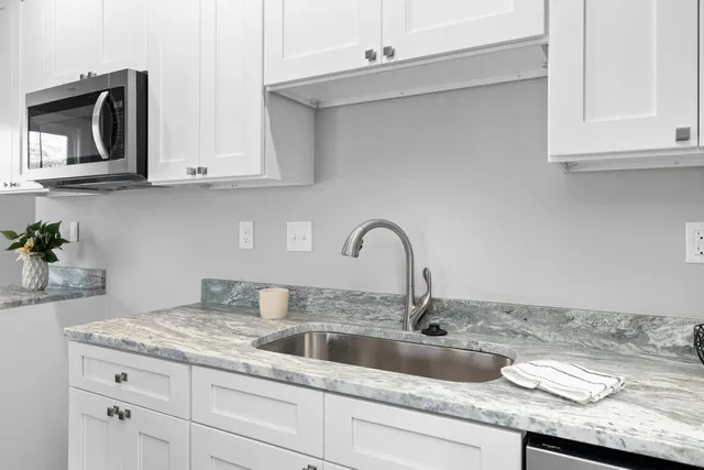 a kitchen with granite countertop a sink and cabinets