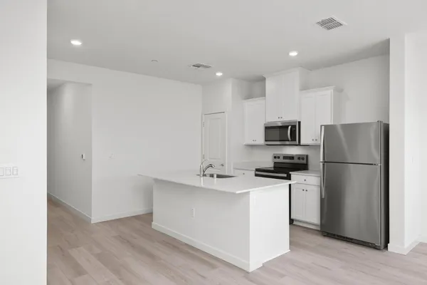 a kitchen with stainless steel appliances a refrigerator stove microwave and sink