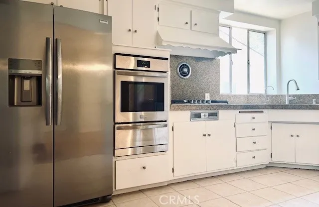 a kitchen with cabinets stainless steel appliances and sink