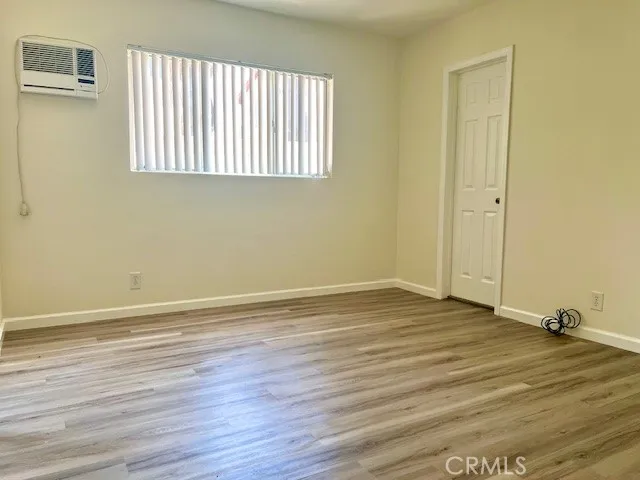 a view of a room with wooden floor and a window