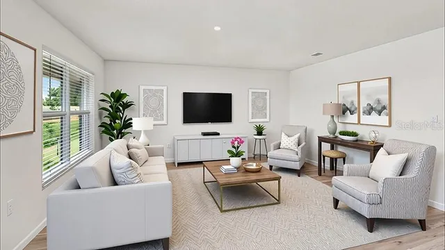 a living room with furniture flat screen tv and a large window