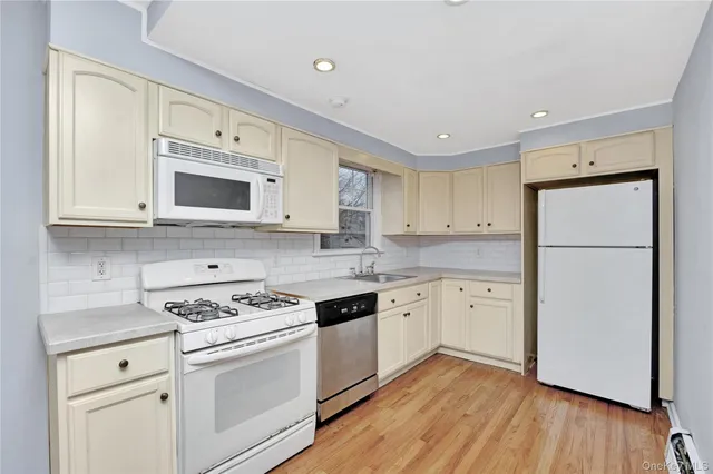 a kitchen with granite countertop white cabinets and white appliances
