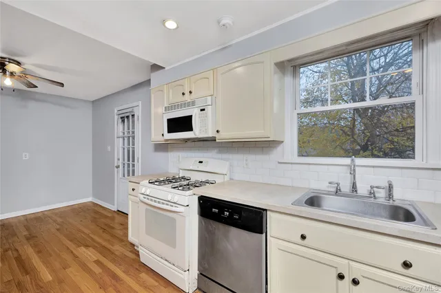 a kitchen with stainless steel appliances granite countertop a sink stove and microwave