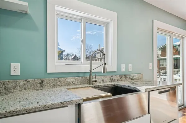 a view of a kitchen with granite countertop a sink and a window