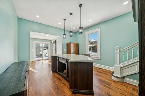 a kitchen with stainless steel appliances granite countertop a stove and a wooden floors