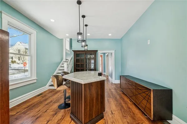 a view of a room with wooden floor staircase and a kitchen