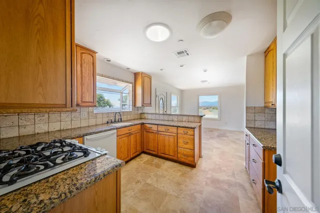 a view of a backyard of the house with a yard