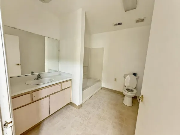 a bathroom with a granite countertop sink mirror and toilet