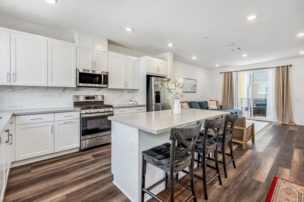 1978 Affinity Lane Chula Vista, CA 91915 - Photo 9 of 26 a kitchen with stainless steel appliances kitchen island granite countertop a stove a sink a refrigerator and a microwave