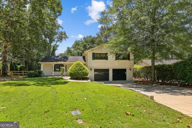 a front view of a house with a yard and trees