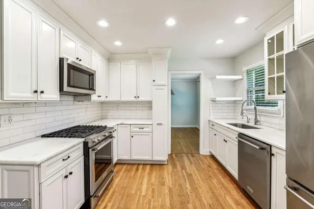 a kitchen with granite countertop cabinets stainless steel appliances and wooden floor