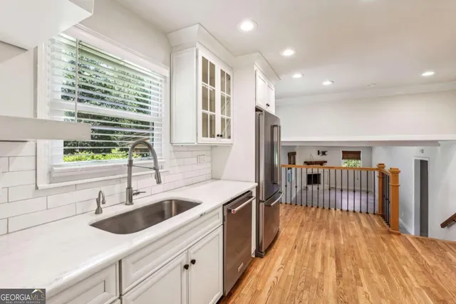a kitchen with a sink and wooden floor