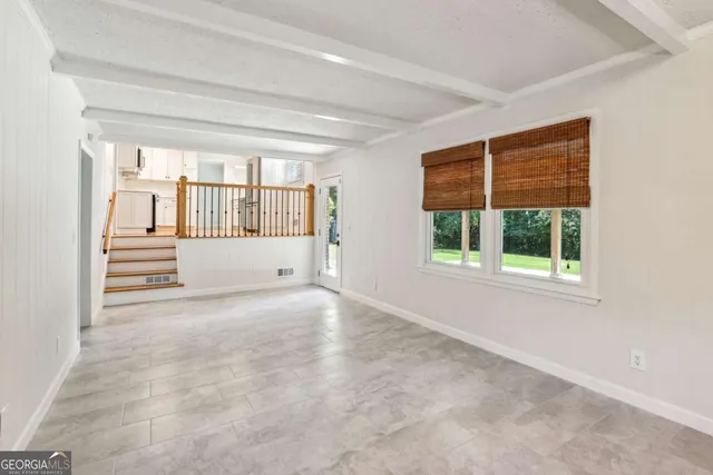 an empty room with a fireplace and windows