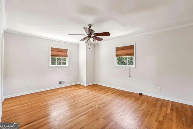 a view of a big room with wooden floor and a ceiling fan