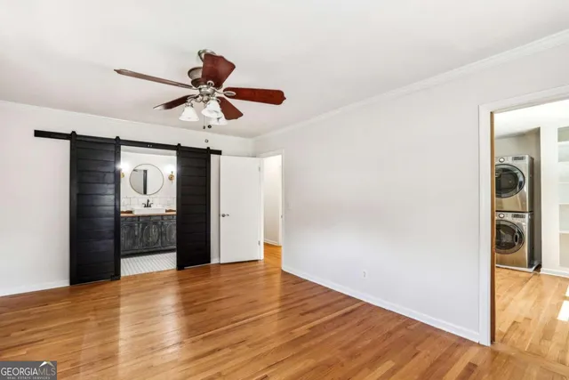 a view of a livingroom with a chandelier fan and wooden floor