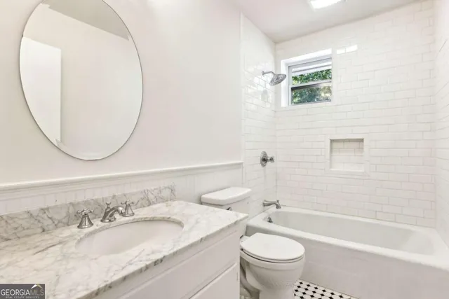 a bathroom with a granite countertop toilet a sink and a mirror