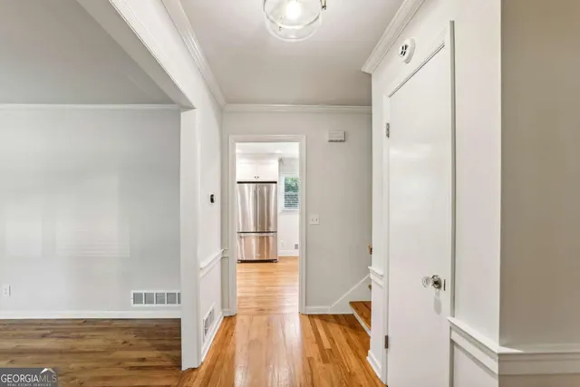 a view of a hallway with wooden floor and staircase