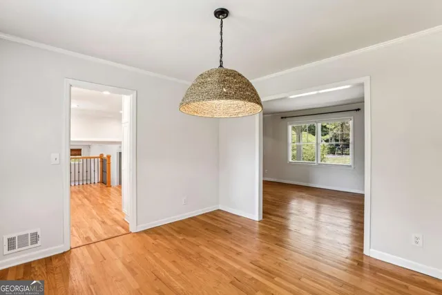 a view of a room with wooden floor staircase and a kitchen